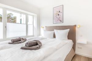 ein Schlafzimmer mit einem großen Bett mit Handtüchern darauf in der Unterkunft Ferienwohnung Sonnenschein Haus Hiddensee Prora in Binz