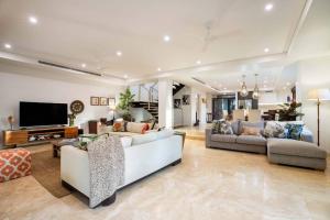 uma sala de estar com dois sofás e uma televisão em NYARU Villa Port Douglas, QLD em Port Douglas