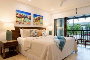 um quarto com uma cama grande e uma varanda em NYARU Villa Port Douglas, QLD em Port Douglas
