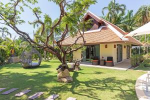 a tree in the yard of a house at Villa Carlos, Luxury 7 BDR Private Pool Villa, Baan Bua Nai Harn, Phuket in Rawai Beach