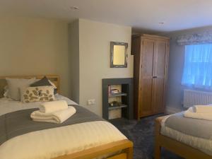 a bedroom with two beds and a mirror and a window at The White Hart Apartment Church View in Alton