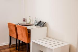 a white desk with two chairs and a phone at Hotel Gut Landscheid in Burscheid