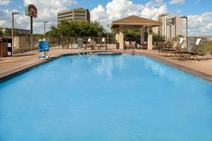 a large blue swimming pool with chairs and a gazebo at Staybridge Suites San Antonio Airport, an IHG Hotel in San Antonio