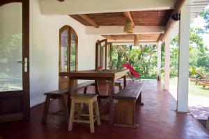 una sala da pranzo con tavolo in legno e panche di Analatsara Eco Lodge a Ile aux Nattes