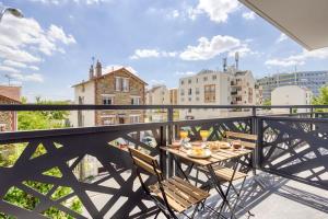 a balcony with a table and chairs on a balcony at Le Central - Parking - 10' Paris - 30' Disneyland in Fontenay-sous-Bois
