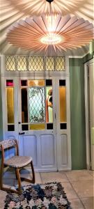 a room with a door with a bench and a chandelier at Villa Aigarden maison d'hôtes in Avignon