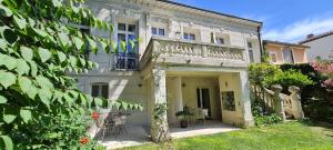 - un bâtiment avec un balcon, des tables et des chaises dans l'établissement Villa Aigarden maison d'hôtes, à Avignon