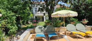 a group of chairs and an umbrella in a garden at Villa Aigarden in Avignon