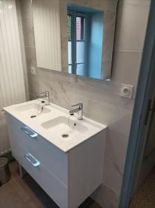 een badkamer met een witte wastafel en een spiegel bij Gite de la Croix de la Passion in Vailly-sur-Sauldre