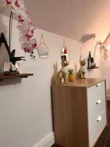 a dresser with two figurines on top of it at Bv Comfy Attic Studio At Deighton Huddersfield in Huddersfield