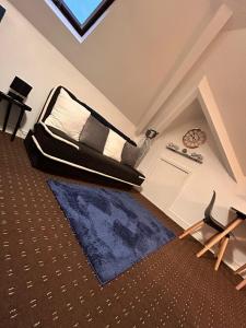 1 dormitorio con cama y alfombra azul en Bv Comfy Attic Studio At Deighton Huddersfield, en Huddersfield