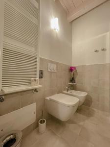 biała łazienka z toaletą i umywalką w obiekcie Agriturismo Ortaglia Bardolino w mieście Bardolino