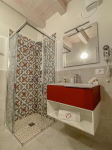 a bathroom with a shower and a sink and a mirror at Agriturismo Ortaglia Bardolino in Bardolino