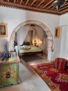 a bedroom with a bed with an archway in a room at Maison Leila in Midoun