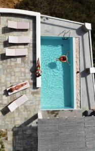 a person swimming in the water in a pool at Villa Giulia, seaview villa in Ios Chora