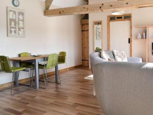 a living room with a table and chairs and a couch at The Old Cow Shed in Wickwar