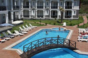 a swimming pool with a bridge and a building at Lighthouse Legend Aparts in Fethiye