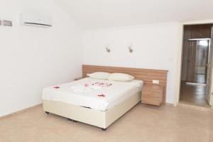 a white bedroom with a bed with flowers on it at Lighthouse Legend Aparts in Fethiye