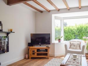 a living room with a flat screen tv on a wooden table at Elizabeth House in Chirk