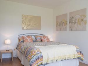 a bedroom with a bed and two pictures on the wall at Elizabeth House in Chirk