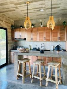 a kitchen with wooden cabinets and a counter with stools at Casa Carmela 