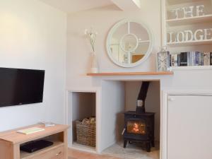 a living room with a fireplace and a television at The Lodge At Elmley Meadow in Little Comberton
