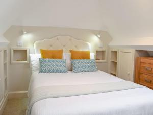 a bedroom with a large bed with orange and blue pillows at The Lodge At Elmley Meadow in Little Comberton