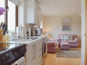 a kitchen with a sink and a living room at The Lodge At Elmley Meadow in Little Comberton