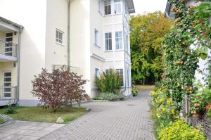 ein weißes Gebäude mit einem Apfelbaum davor in der Unterkunft Bansin, Villa an der Waldstraße in Bansin