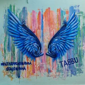 a painting of blue wings on a colorful wall at Tabbu ibiza apartments in Playa d'en Bossa