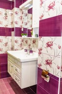 a bathroom with a sink and purple and white wallpaper at KRISSTY Apartment in Veliko Tŭrnovo