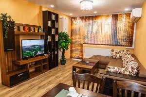 a living room with a couch and a tv at KRISSTY Apartment in Veliko Tŭrnovo