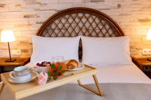 a bed with a tray of food on a table at Casa Alegria in Olympiada