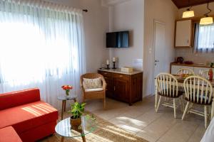 a living room with a red couch and a table at Casa Alegria in Olympiada