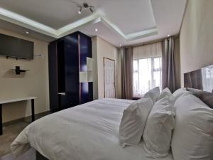 a bedroom with a large bed with white pillows at KwaNomzi Botique Lodge in Lusikisiki