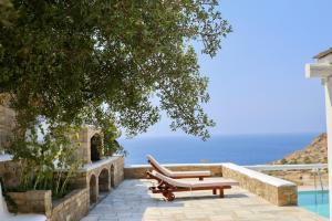 a couple of benches sitting next to a pool at Villa Giulia, Seaview Villa in Ios Chora