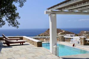 a patio with a pool and a chair and the ocean at Villa Giulia, Seaview Villa near Chora in Ios Chora