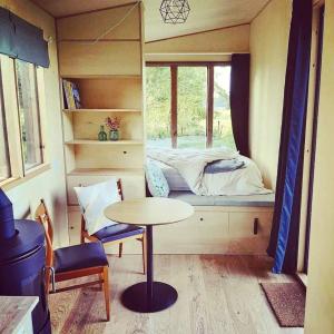 Cette petite chambre comprend une table et un lit. dans l'établissement Nice and Slow : Eco-responsible tiny house, 