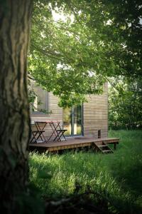 a house with a picnic table on a deck at Nice and Slow : Eco-responsible tiny house 