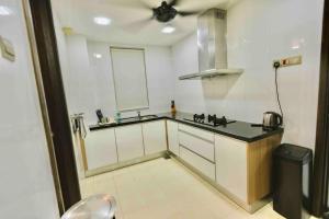 uma cozinha branca com um lavatório e um balcão em Luxury House near KL City for Vacation and Retreat em Ampang
