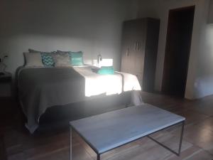 1 dormitorio con cama y mesa de centro en Nuestra Esquina en Valeria del Mar