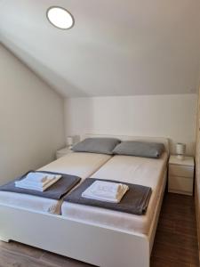 una camera da letto con un letto e due asciugamani di Apartments Jungic, Rab a Rab