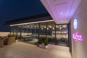un restaurant avec des tables et des chaises et un panneau de néon dans l'établissement Country Inn Hall of Heritage Amritsar, à Amritsar