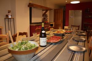 a table with a bottle of wine and a salad at Le Hameau de Chantemerle in Samoëns