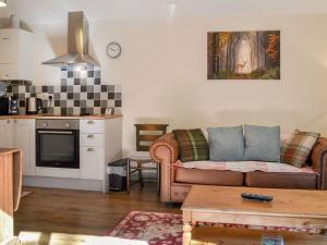 a living room with a couch and a kitchen at Hazels Cottage in Hayton
