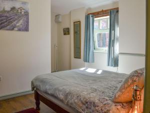 a bedroom with a bed and a window at Hazels Cottage in Hayton