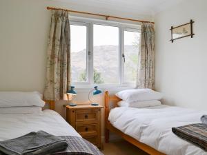 a bedroom with two beds and a window at Invernoe Cottage in Taynuilt