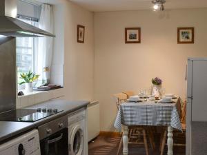 a kitchen with a table with a table cloth at Browney Cottage in Broadwood