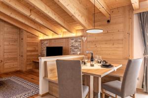 ヴィーゴ・ディ・ファッサにあるLuxury Apartment Majon de Ritaの木製のテーブルと椅子のあるダイニングルーム