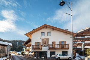 a building with a balcony on the side of it at Luxury Apartment Majon de Rita in Vigo di Fassa